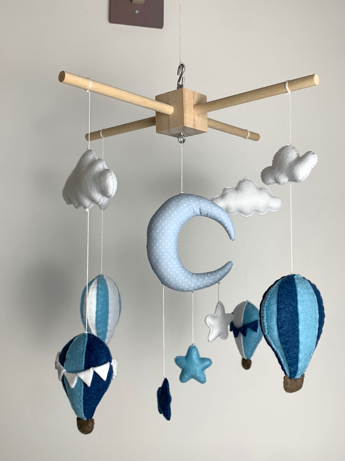 Mobile bébé entièrement fait main dans les tons bleus et blancs, composé de montgolfières, d’étoiles, de nuages et d’une lune